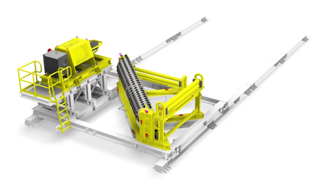 Industrial machinery with yellow safety railings and components, including a slanted conveyor or roller system and control panel, mounted on a white metal base with rails extending outwards.